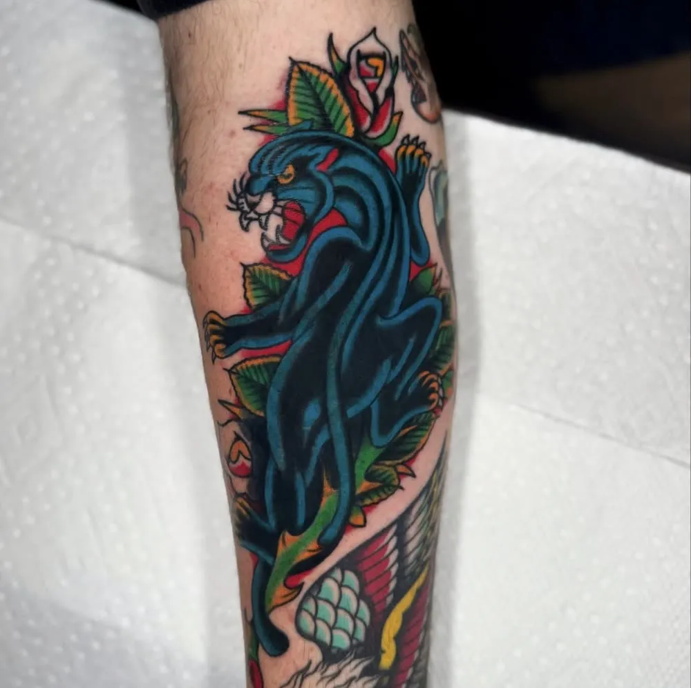 Panther climbing through roses, color traditional forearm tattoo